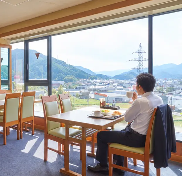 窓から和田山の街並みと山々を望む朝食会場（レストラン）